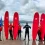 Adults posing with surf board on beach