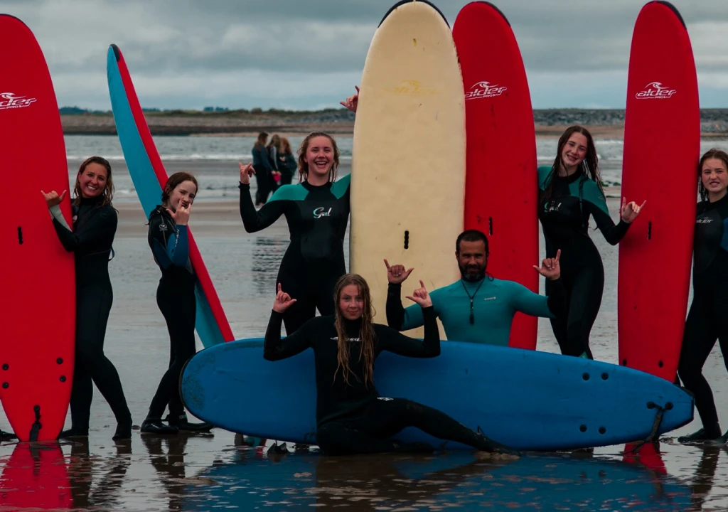 Adults posing with surf board on beach