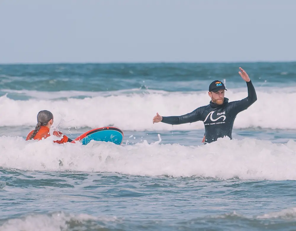 Guide giving surfing lessons in ocean