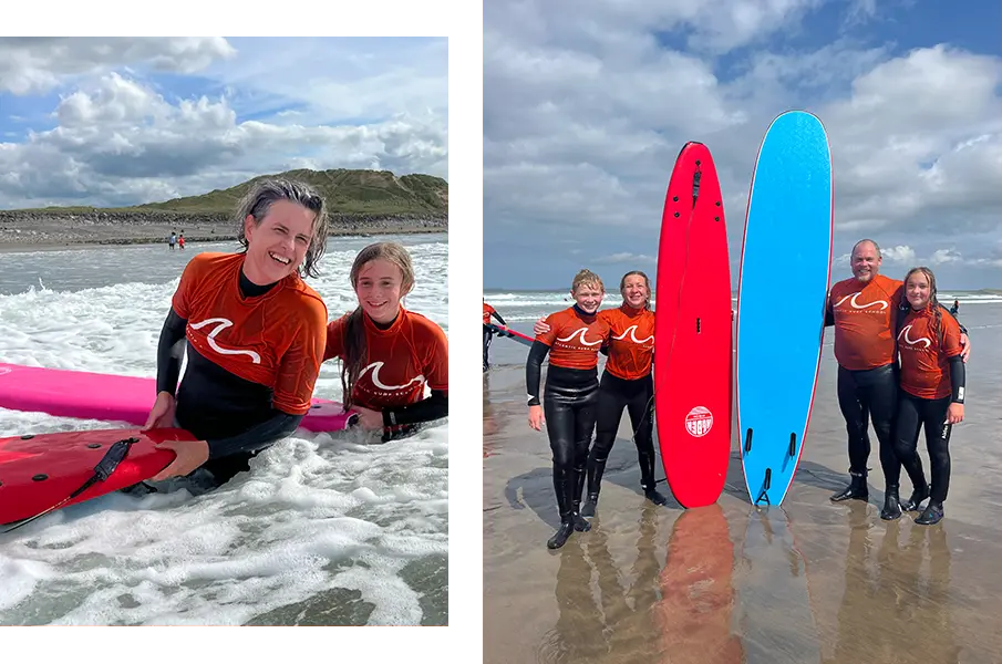 Family posing with surf boards on beach and two family members surfing in ocean