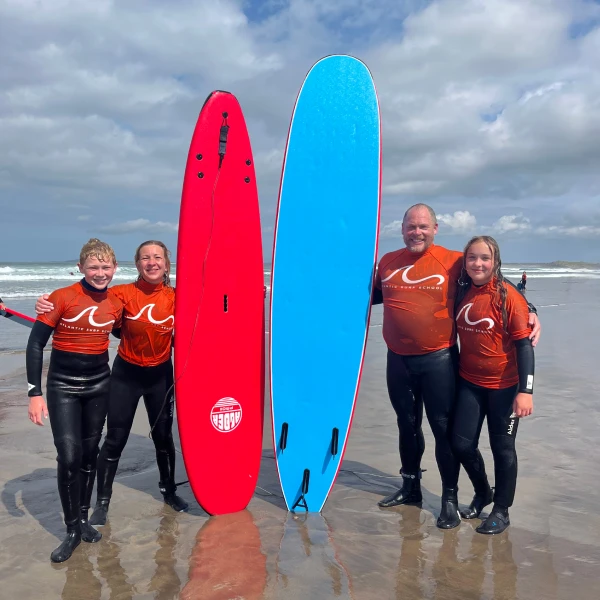 A family posing with surf boards on beach